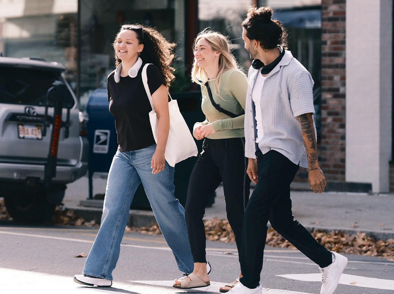 Friends using neck fan for hands-free cooling while walking outdoors on a sunny street