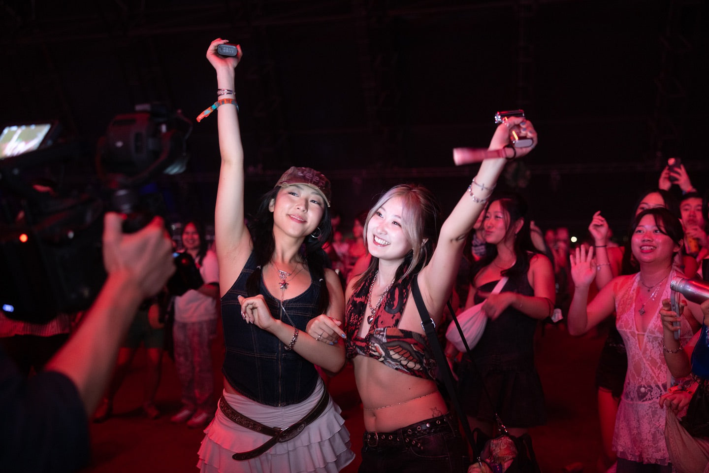 Jisulife handheld fan held by festival-goer at outdoor summer music festival with a large crowd in the background